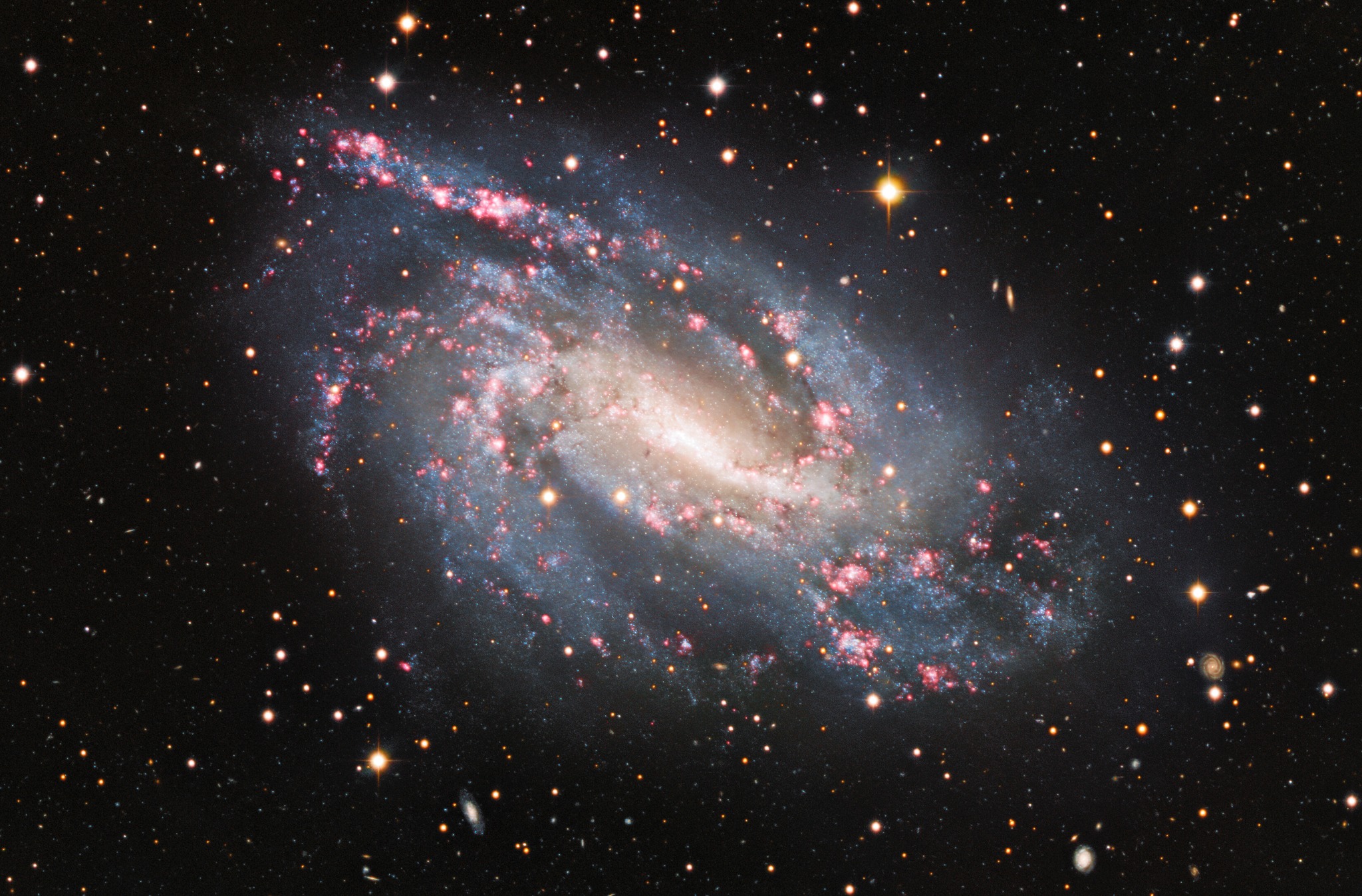 Composite optical image of the Amatha Galaxy (NGC 925), a barred spiral galaxy in Triangulum showing pink H II star-forming regions along its offset bar and spiral arms
