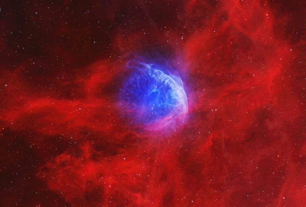 Blue bubble nebula around Wolf-Rayet star WR 134 glowing inside red hydrogen clouds in Cygnus, captured in Hα and [O III] narrowband by Jose Luis Bedmar.
