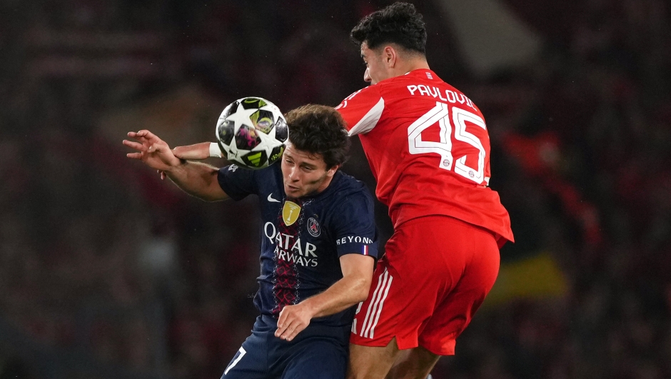 PSG midfielder Vitinha battles Bayern Munich's Pavlović in an aerial duel during the dramatic 2025 Champions League clash, Qatar Airways jersey visible.