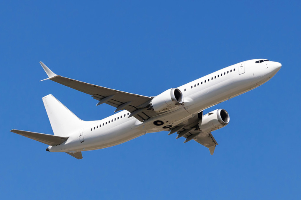 White airplane flying against blue sky