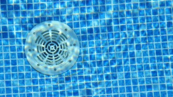 Pool drain in blue tiled water