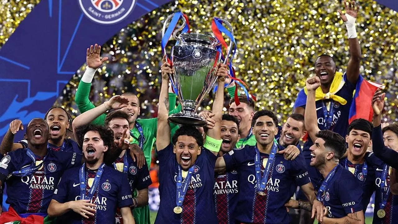 Marquinhos lifts the UEFA Champions League trophy as PSG players celebrate their 2026 final win against Arsenal in Budapest, surrounded by golden confetti.