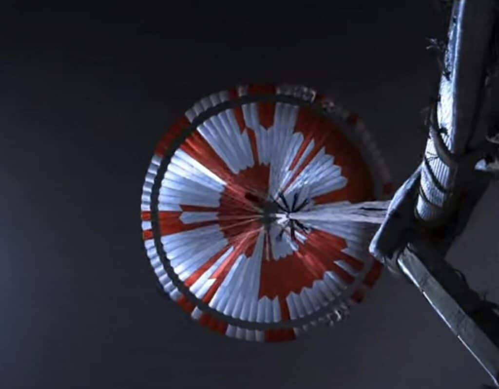 NASA Perseverance deploys its red-and-white supersonic parachute during descent through the Martian atmosphere
