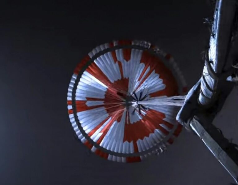 NASA Perseverance deploys its red-and-white supersonic parachute during descent through the Martian atmosphere