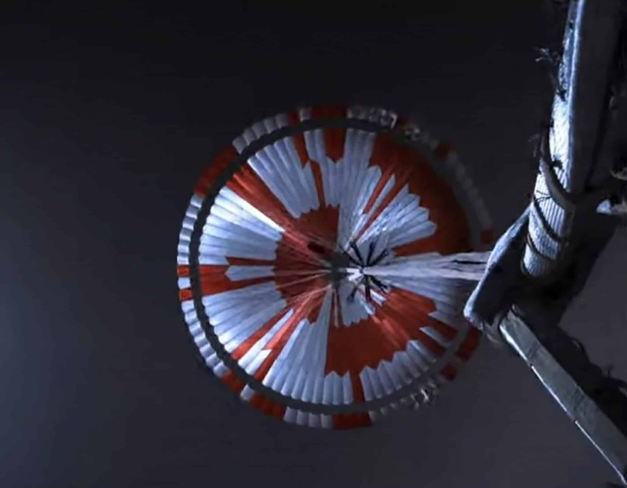 NASA Perseverance deploys its red-and-white supersonic parachute during descent through the Martian atmosphere