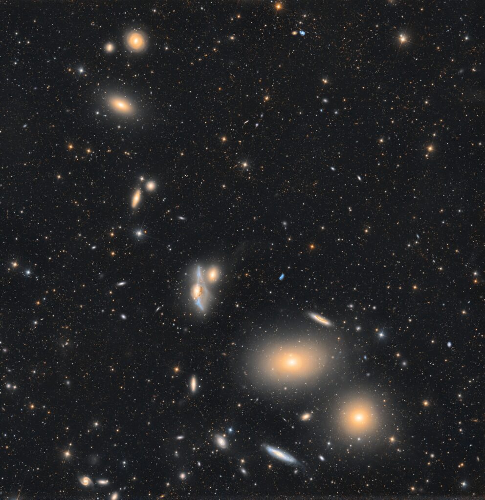 Markarian’s Chain arc in the Virgo Cluster with M84, M86, NGC 4438, NGC 4435, and a faint tidal bridge amid star fields.
