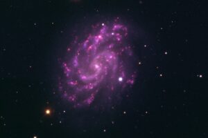 NGC 5584 barred spiral galaxy in Virgo with purple star-forming arms and bright foreground stars